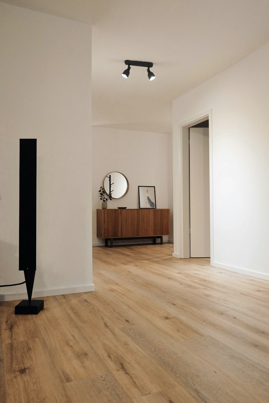 Ambiente ristrutturato con parquet nuovo, pareti bianche e illuminazione moderna